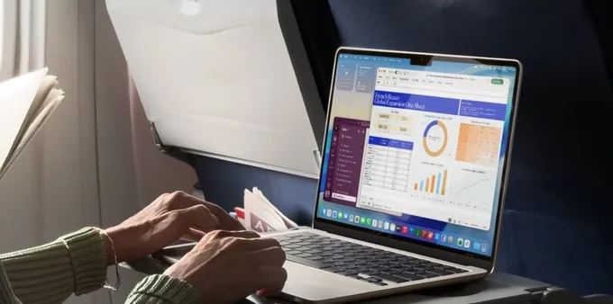 A person working on a MacBook Air in a plane