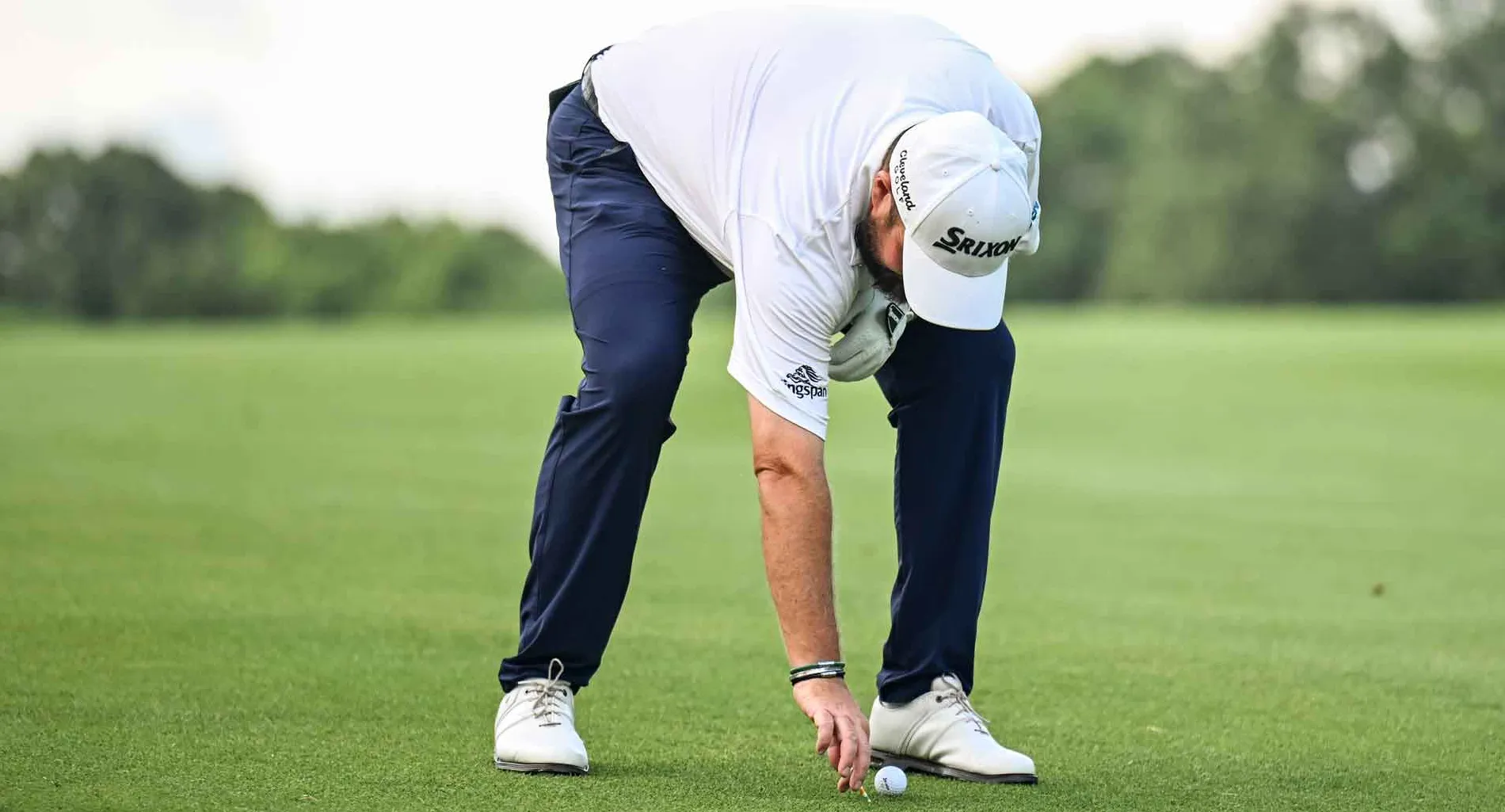 Shane Lowry of Ireland places his ball back down with preferred lies in effect on the 14th hole after heavy rainfall during the third round of the Travelers Championship at TPC River Highlands on June 22, 2024, in Cromwell, Connecticut.