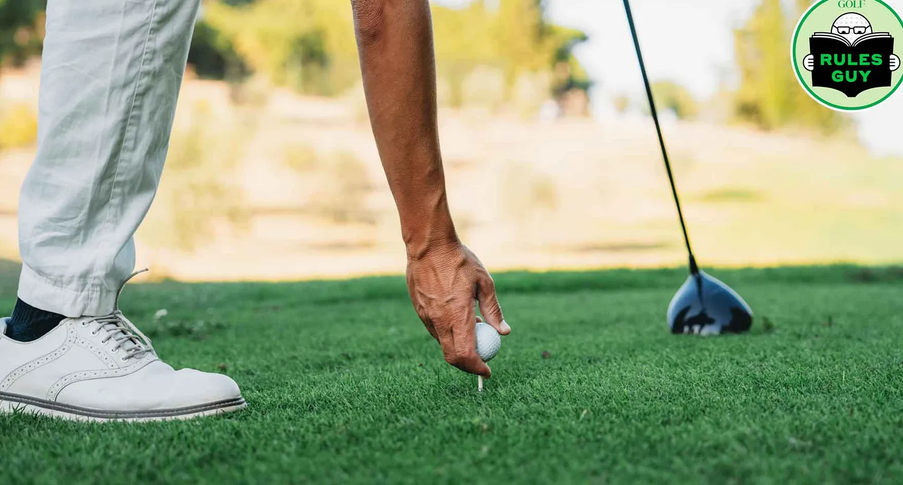 A golfer is preparing for strike. Close up detail of his hand holding the ball.
