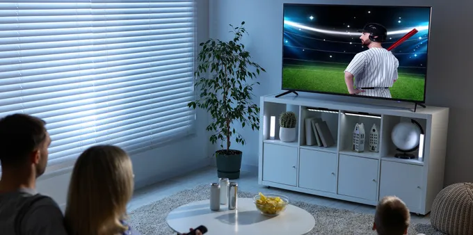 Family watching a baseball game at home.